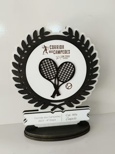 a black and white trophy with a tennis racquet on it's side