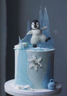 a birthday cake with a penguin on top