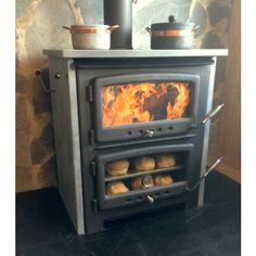 a wood burning stove in a kitchen with pots and pans on top