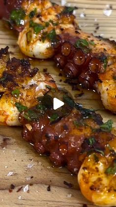 grilled shrimp and olives on a wooden cutting board