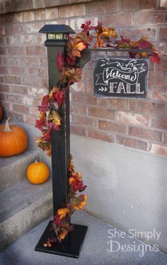 a lamp post decorated with fall leaves and pumpkins