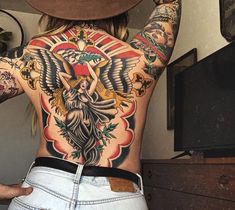 a woman with tattoos on her back and arms