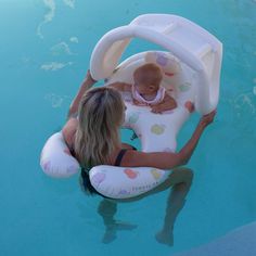 a mother and her baby in an inflatable pool