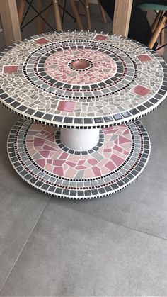 three tiered mosaic table with chairs in the background