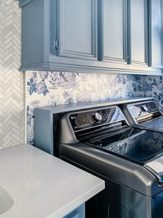 a washer and dryer in a kitchen with blue cabinets