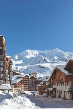 snow covered buildings and mountains in the background