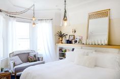 a white bed sitting in a bedroom next to a window