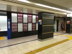 an empty subway station with people standing in the doorway and on the other side of the platform