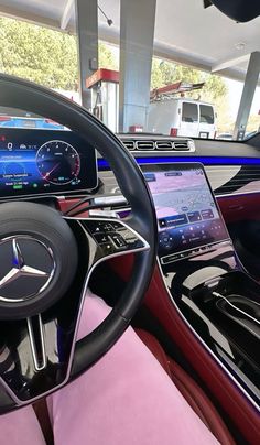 the inside of a car with dashboard, steering wheel and display screen showing various vehicles