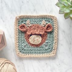 a crocheted square with a brown bear on it