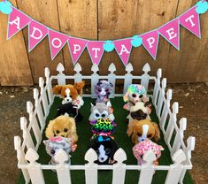 a group of stuffed animals sitting in a fence