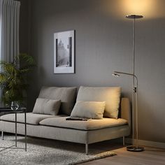 a living room scene with focus on the couch and floor lamp in the foreground