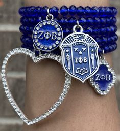 a close up of a person's arm with bracelets and charms on it