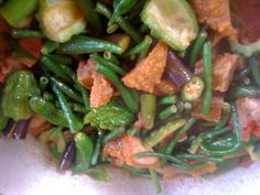 green beans, carrots and other vegetables are mixed together in a bowl on the table