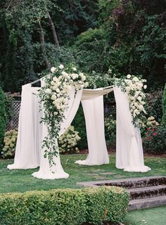 an outdoor wedding setup with white flowers and greenery