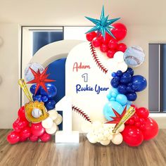 an arch with balloons and baseballs on it