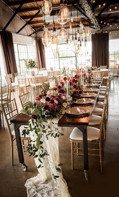 a long table is set with flowers and candles for an elegant wedding reception at the winery