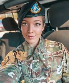 a woman in uniform is sitting in the back seat of a car and smiling at the camera