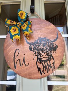 a wooden sign with a buffalo head and sunflowers on it's front door