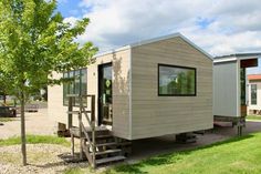 a tiny house sitting on top of a lush green field