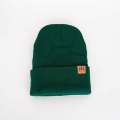 "Add a touch of nature with our Three Tree Foldover Beanie - Emerald. Featuring a suede small patch and a stylish fold over design, this beanie will keep you cozy and on trend. Perfect for chilly days and adventurous souls." One size fits all. A Montana Scene Original Design. All designs are property of The Montana Scene. All rights reserved.All of The Montana Scene apparel is designed and printed locally in Montana. Come visit our storefront locations! Bigfork * Whitefish * Missoula * Kalispell Fall Green Cotton Hat, Adjustable Solid Beanie For Outdoor, Cozy Hats With Fleece Lining For Fall, Trendy Outdoor Beanie One Size, Green Winter Hat For Everyday Use, Warm Hat For Outdoor Fall Use, Trendy One Size Beanie For Outdoor, Green Beanie For Cold Weather, Warm Green Casual Beanie