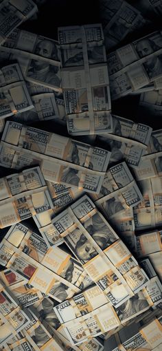 a pile of twenty dollar bills laying on top of each other in front of a black background