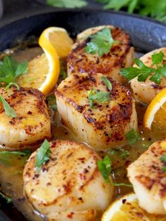 seared scallops with lemon and parsley in a cast iron skillet