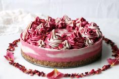 a cake with pink frosting and flowers around it