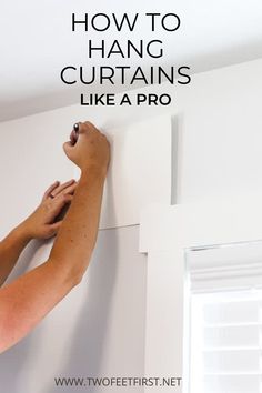 someone is painting the wall with white paint and writing how to hang curtains like a pro