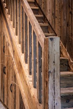 a wooden stair case with metal handrails