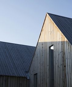 two wooden buildings side by side against a blue sky