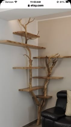 a living room filled with furniture and a tree like shelf next to a black leather chair