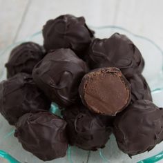 a glass bowl filled with chocolate covered truffles on top of a table