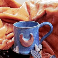 a blue coffee cup with an elephant decoration on it