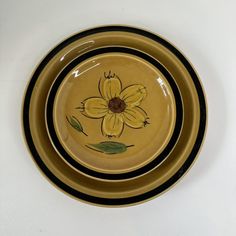 two yellow and black plates with flowers painted on them