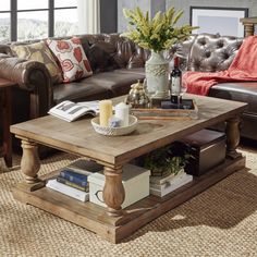 a living room with leather couches and a coffee table in the middle, surrounded by books