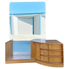 a mirror that is sitting on top of a dresser next to a shelf with drawers