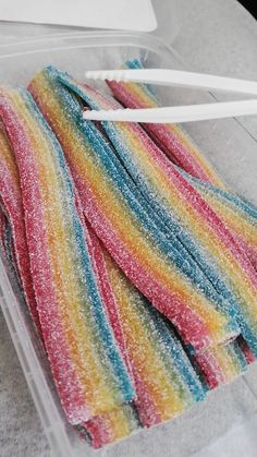 a pair of colorful towels sitting on top of a plastic container next to a white toothbrush