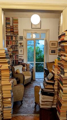 a room filled with lots of books next to a doorway covered in stacks of books