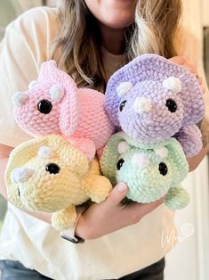 a woman holding three stuffed animals in her hands