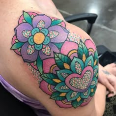 a woman's colorful tattoo on her stomach shows an intricate flower design with hearts