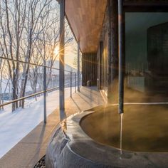 the sun shines brightly in front of a building with a water fountain on it