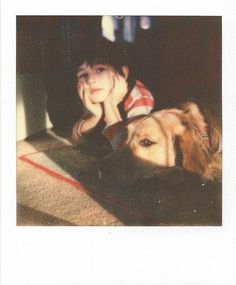 a young boy laying on the floor next to a dog