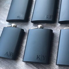 six black flasks sitting on top of a wooden table