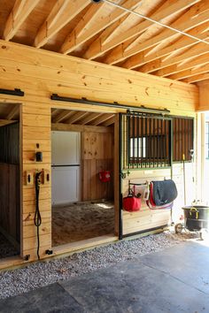 the inside of a horse barn with doors open