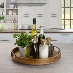 a wooden tray with bottles and spices on it