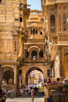 people are walking through an old city street