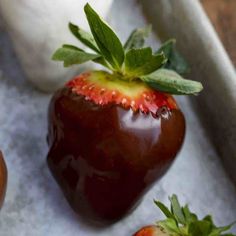 three chocolate covered strawberries on a tray