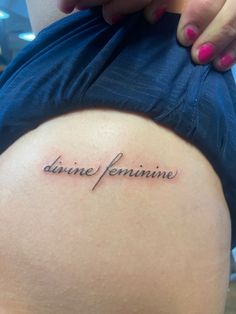 the back of a woman's stomach with an inscription on it that reads divine feminine