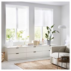 a living room with white furniture and large windows